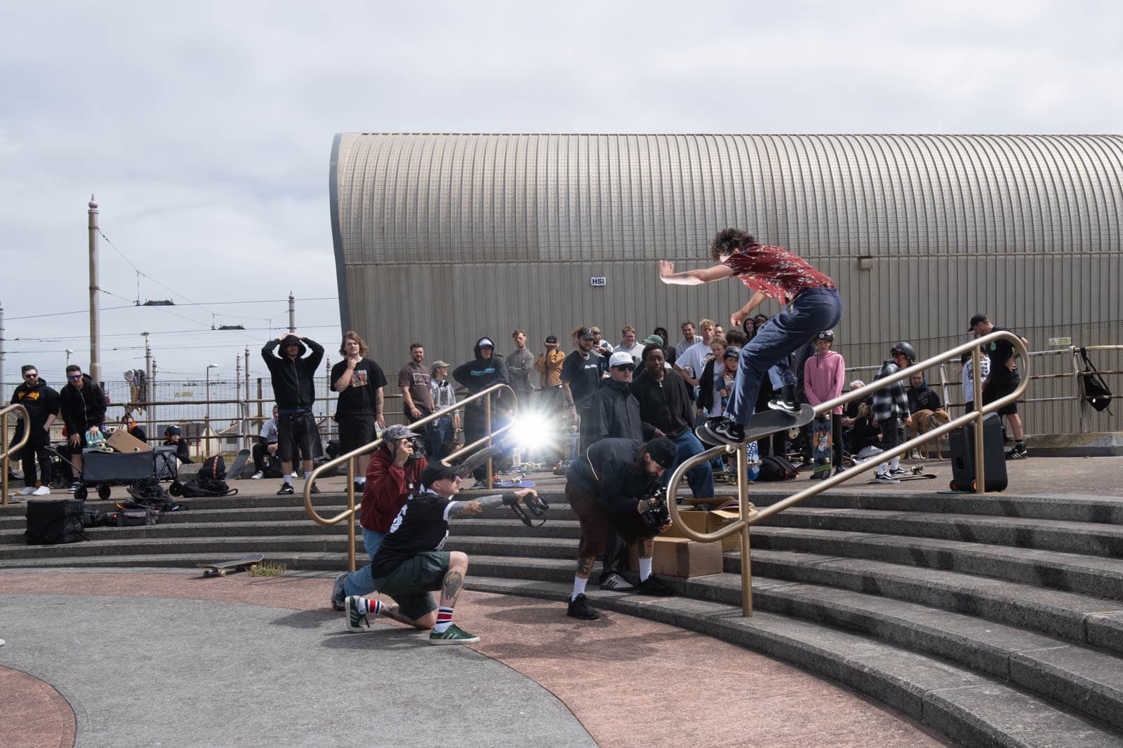 Flash illuminates a skater grinding a handrail