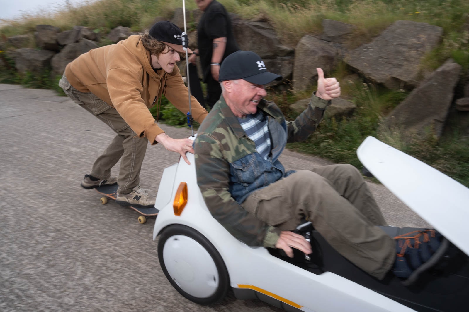 Passer-by gives skater a lift on the back of his buggy