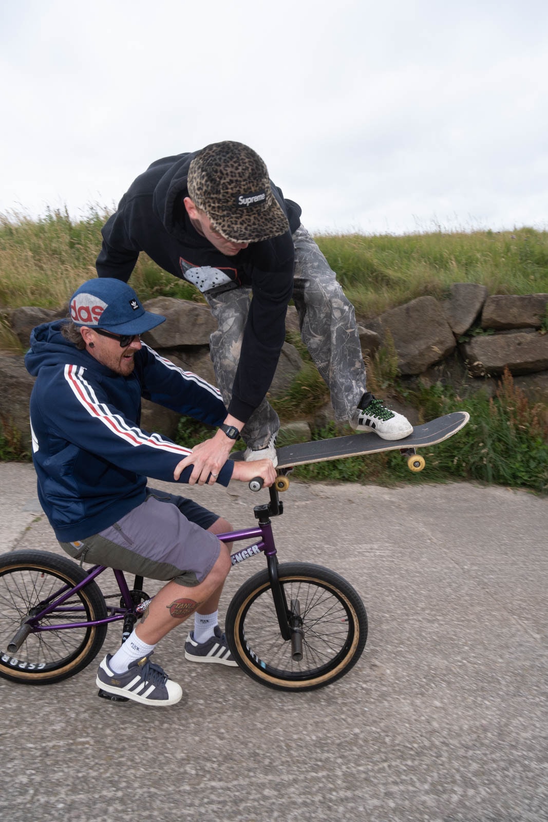 Skater attempts to stall on BMX handlebars while riding downhill
